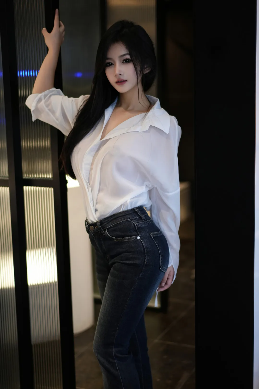 谭小灵身穿白衬衫与牛仔裤倚门留影