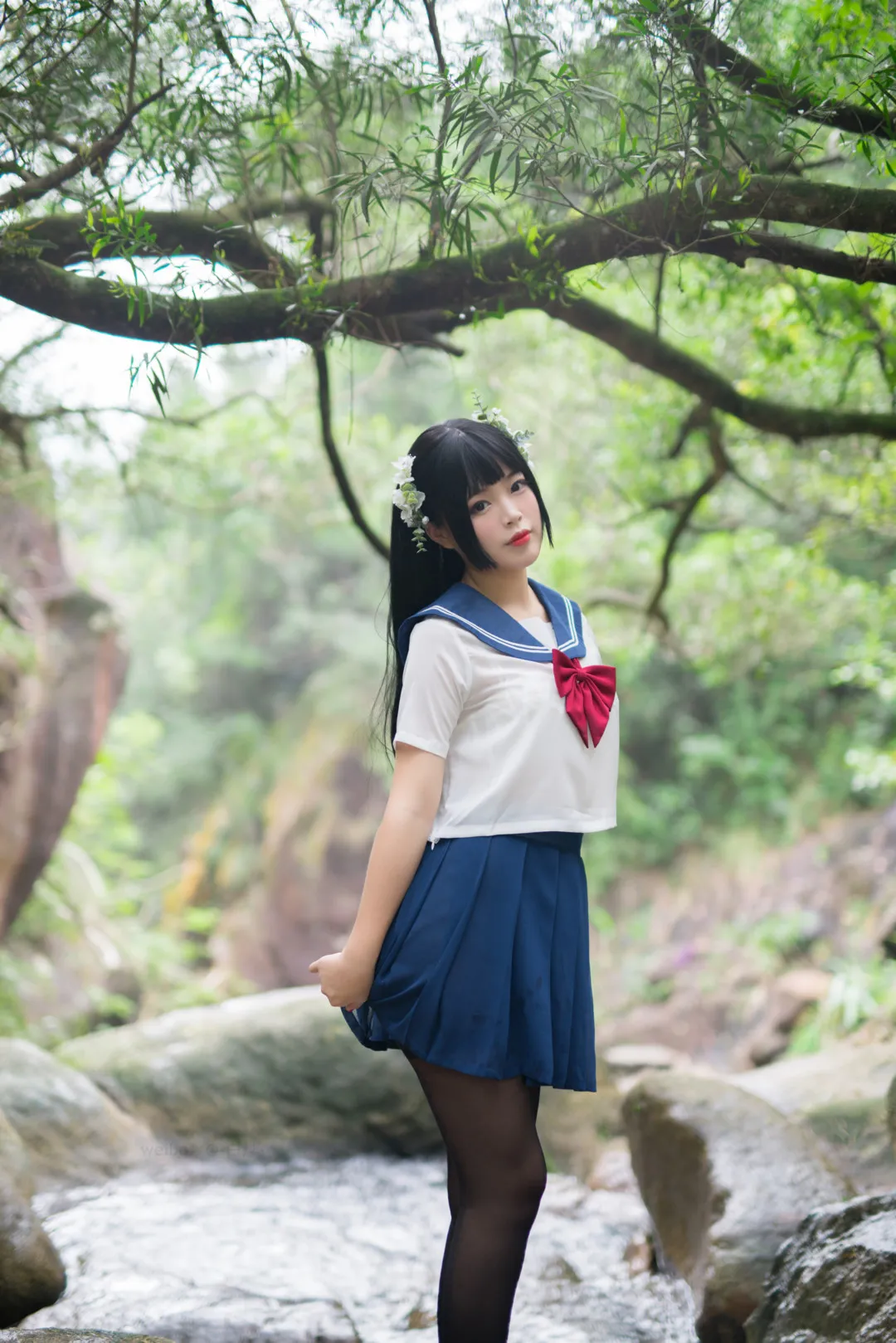 白烨作品目录|作品编号、合集列表与最新更新 白烨蓝白水手制服造型,深色长发搭配浅色花朵发饰,站在树木和溪石之间
